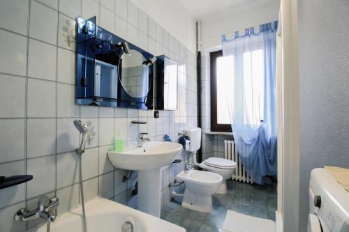 a white bathroom with a sink and a toilet at La Ghiacciaia in Verzuolo