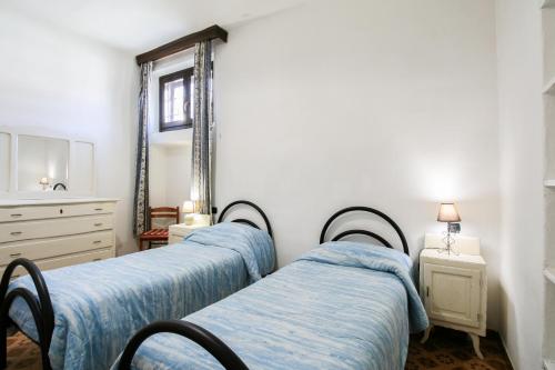a group of three beds in a room with a mirror at La Ghiacciaia in Verzuolo