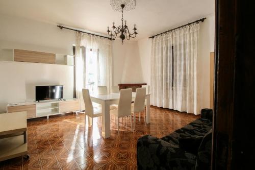 a living room with a dining room table and chairs at La Ghiacciaia in Verzuolo