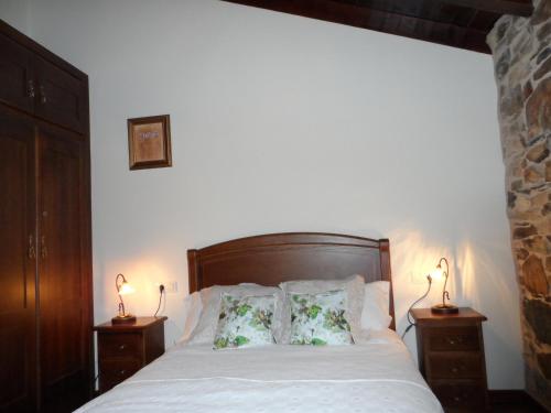1 dormitorio con 1 cama con almohadas y 2 lámparas en A Cantina, en Mouromorto