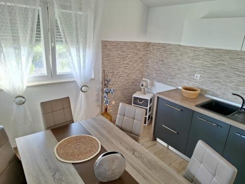 a kitchen and dining room with a table and a sink at Apartmani AS in Jezera