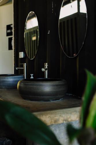 a bathroom with a sink and two mirrors at Nao Hostels Playa Venao in Playa Venao