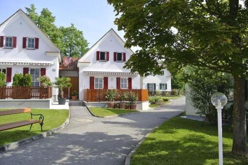 a white house with a bench in front of it at Thermen Apartment in Bad Waltersdorf