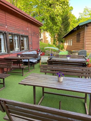 a group of wooden benches sitting outside of a building at Penzion Villa in Janske Lazne