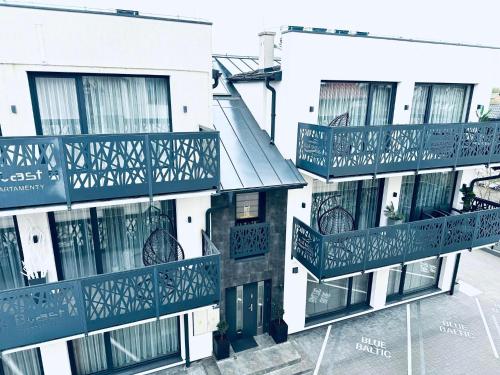 a building with balconies on the side of it at Apartamenty BLUE BALTIC SPA Jacuzzi & Sauna MORZE in Chłopy