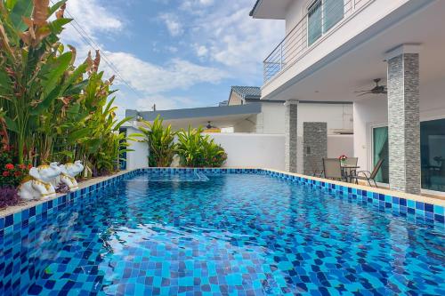 a swimming pool in front of a house with a villa at Pattaya Luxury Villa, 5BR 6BA, Private Pool with Jacuzzi Cityhouse54 in Pattaya South