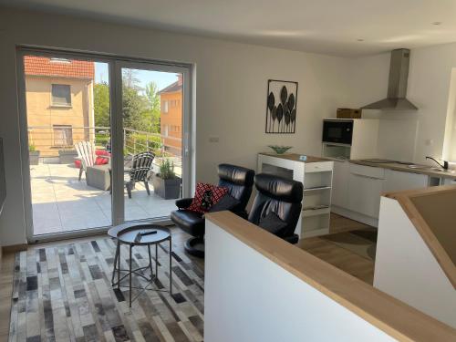 une cuisine avec des chaises en cuir noir et un comptoir avec une table dans l'établissement 2 pièces avec terrasse, à Lingolsheim
