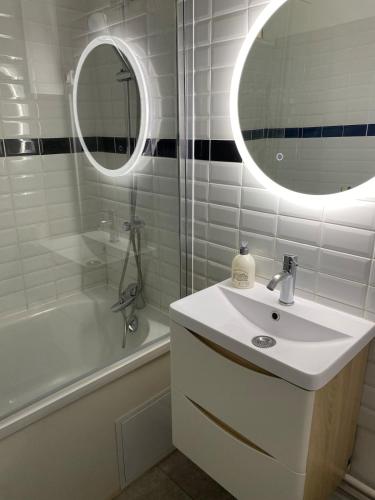 une salle de bain blanche avec un lavabo et un miroir dans l'établissement Magnifique appartement, à Tourcoing