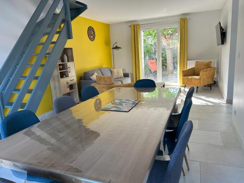 une salle à manger avec une table et des chaises bleues dans l'établissement Maison & studio, jardin, tout confort, à Aigues-Mortes