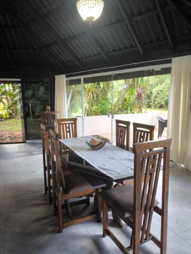 una mesa de comedor y sillas en una habitación con ventana en Chalé com Jacuzzi em Morretes, en Morretes