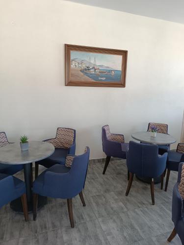 a waiting room with two tables and blue chairs at GOLDEN BEACH in Souvala
