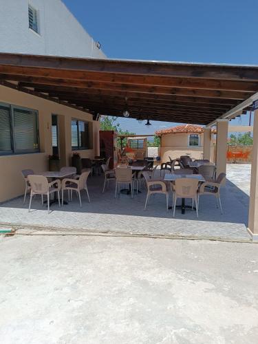 a patio with tables and chairs and a building at GOLDEN BEACH in Souvala