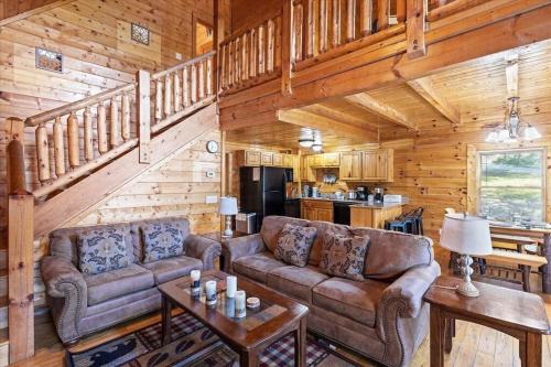 a living room with couches and a kitchen in a cabin at Smokies Outlook by Avada Properties in Pigeon Forge