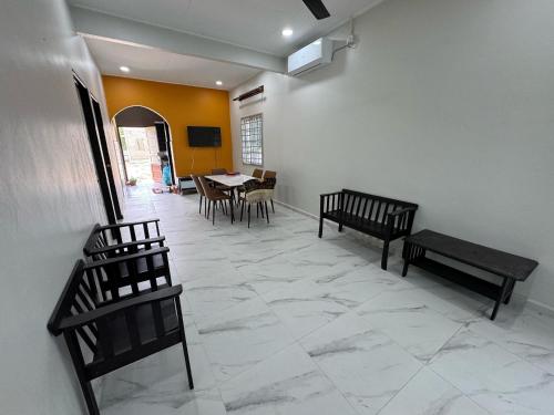 a room with two benches and a table and chairs at Pelandang Homestay Dungun in Kampong Nibong