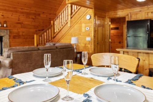a table with glasses and plates on it in a cabin at Smokies Outlook by Avada Properties in Pigeon Forge