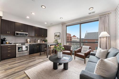 a kitchen and living room with a couch and a table at Brand New Condo in the Heart of Traverse City! in Traverse City