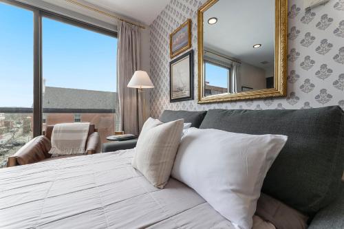 a bedroom with a large bed and a mirror at Brand New Condo in the Heart of Traverse City! in Traverse City
