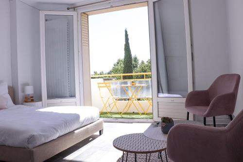 a bedroom with a bed and a chair and a window at Le Luz Charmant T3 in Valence