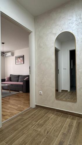 a living room with a mirror and a couch at Apartment ANDI Istocno Sarajevo in Lukavica