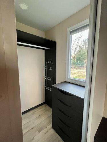 un placard avec une armoire noire et une fenêtre dans l'établissement Mobil home climatisé Louisiana 4 pers, à Sémussac