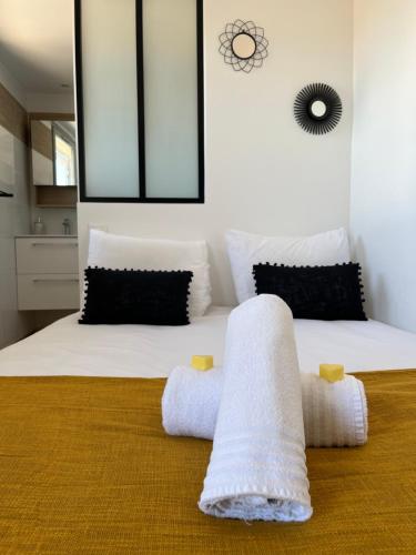 une chambre avec un lit avec des serviettes dessus dans l'établissement Chez Balthazar n3 Arles centre, à Arles