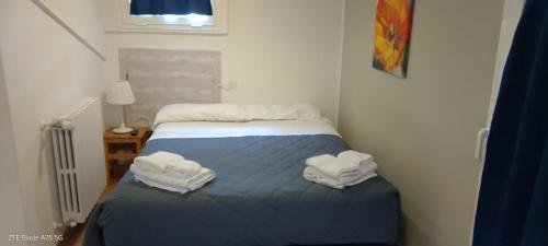 a small bedroom with a bed with towels on it at La Castagna Matta in Albareto