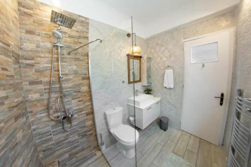 カト・コラキアナにあるFiona's House Apartmentsのトイレとガラスのシャワー付きのバスルーム