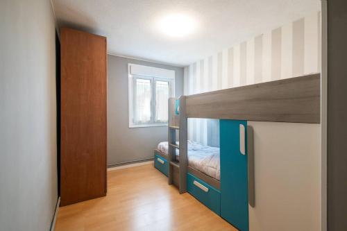 a small bedroom with a bunk bed and a door at Durmiendo en el Paraiso in Llanes