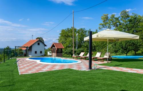 a patio with an umbrella and a swimming pool at Awesome Home In Aljmas With Sauna in Aljmaš