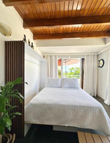 Un dormitorio con una cama blanca con una ventana. en Loft Bahía Fragata, en San Andrés