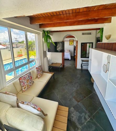 Una sala de estar con sofá y una habitación con piscina. en Loft Bahía Fragata, en San Andrés