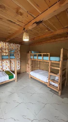 two bunk beds in a room with a wooden ceiling at Mountain Mamma in Shangarh