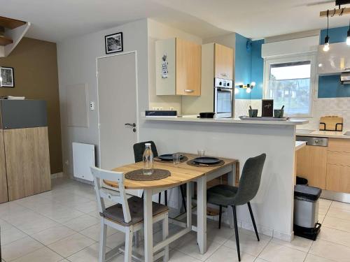 une cuisine avec une table et des chaises en bois dans l'établissement 1006 - Maison 4p dans une résidence privée avec piscine., à Pléneuf-Val-André