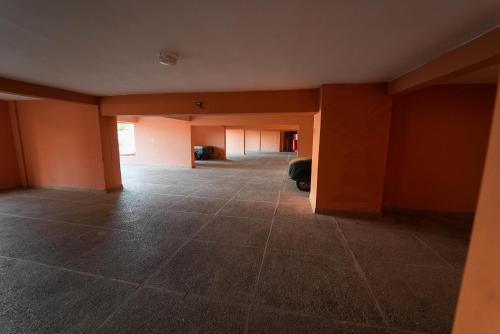 an empty room with orange walls and tile floors at Imi Waves Studio - Steps from Beach & Surf Spot, Imi ouaddar in Imi Ouaddar