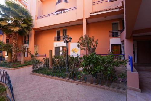 a building with a palm tree in front of it at Imi Waves Studio - Steps from Beach & Surf Spot, Imi ouaddar in Imi Ouaddar