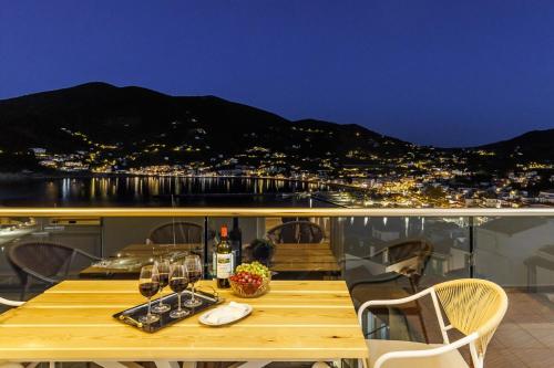 a table with wine glasses on top of a balcony at koukou house skopelos in Skopelos Town