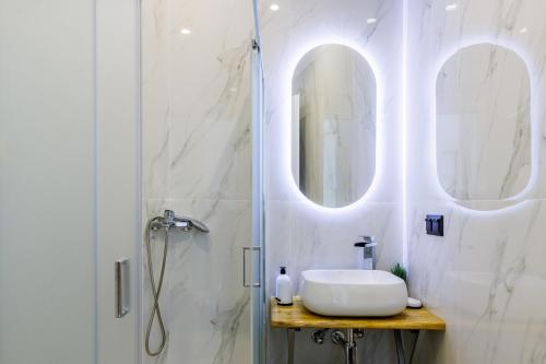 a bathroom with a sink and a shower at koukou house skopelos in Skopelos Town