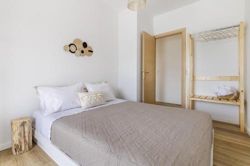 a white bedroom with a large bed and a window at koukou house skopelos in Skopelos Town