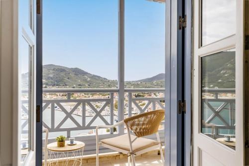 a view from a room with a chair and a window at koukou house skopelos in Skopelos Town