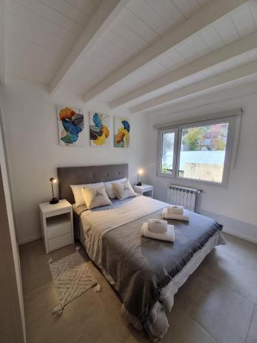 Un dormitorio con una cama grande y una ventana. en Las Araucarias - Andarlibre, en San Martín de los Andes
