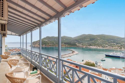 a balcony with a view of the water and a boat at koukou house skopelos in Skopelos Town