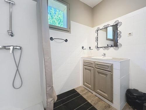 une salle de bain avec un lavabo et un miroir dans l'établissement Le clos des vignes, à Puyméras