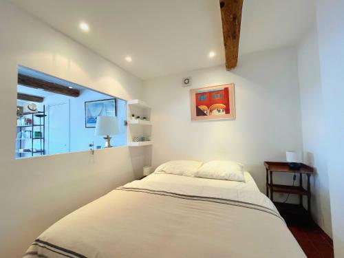 une chambre avec un lit et une fenêtre dans l'établissement Le Palmyre, à Cassis