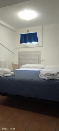a bedroom with a blue bed with a window at La Castagna Matta in Albareto