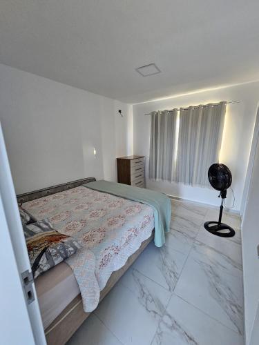 a white bedroom with a bed and a window at Home Duplex Serra Negra - casa 8 in Bezerros