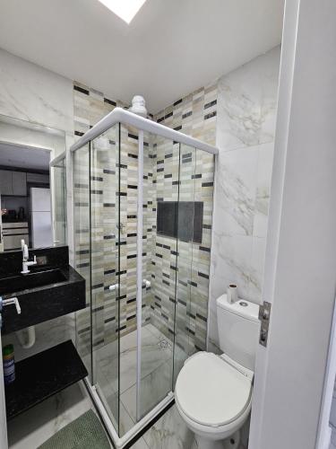 a bathroom with a toilet and a glass shower at Home Duplex Serra Negra - casa 8 in Bezerros