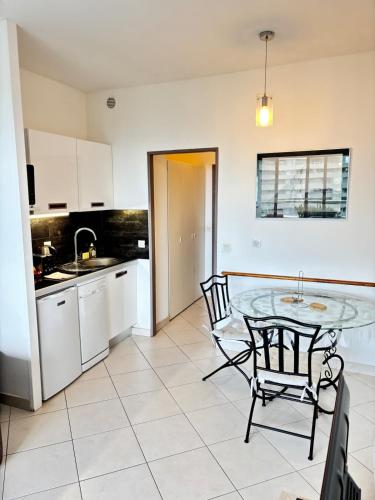 une cuisine avec une table et des chaises dans une pièce dans l'établissement Sea & Port View Cozy Studio at Marina Baie des Anges, à Villeneuve-Loubet