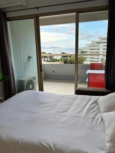 une chambre avec un lit et une vue sur un balcon dans l'établissement Sea & Port View Cozy Studio at Marina Baie des Anges, à Villeneuve-Loubet