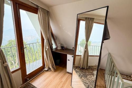 a mirror in a room with a balcony at Himadvaya- The Himalayan Prism in Almora