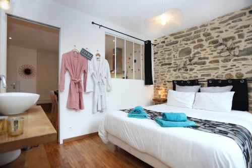 a bedroom with a large bed and a bathroom at La chouette détente in Fougères